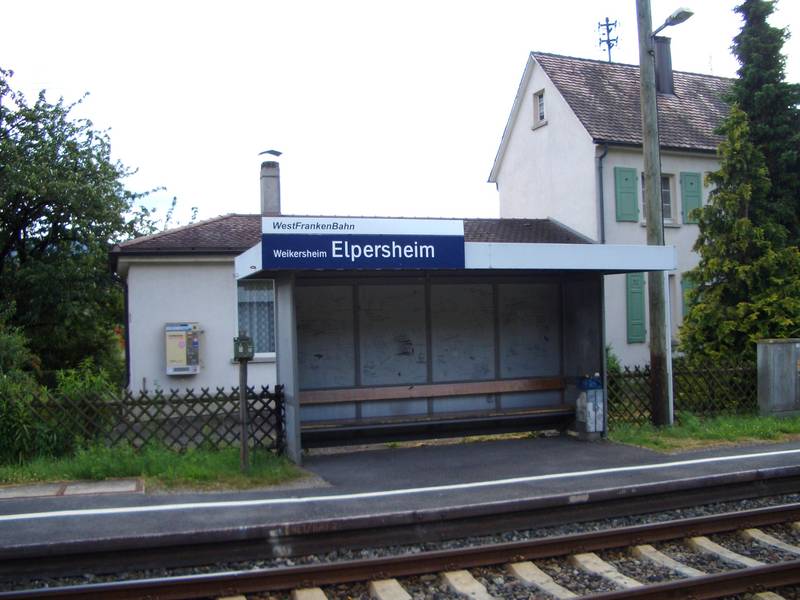 Elpersheim, Haltestelle mit Wartehäuschen. Im Hintergrund das ehem. Bahnhofsgebäude