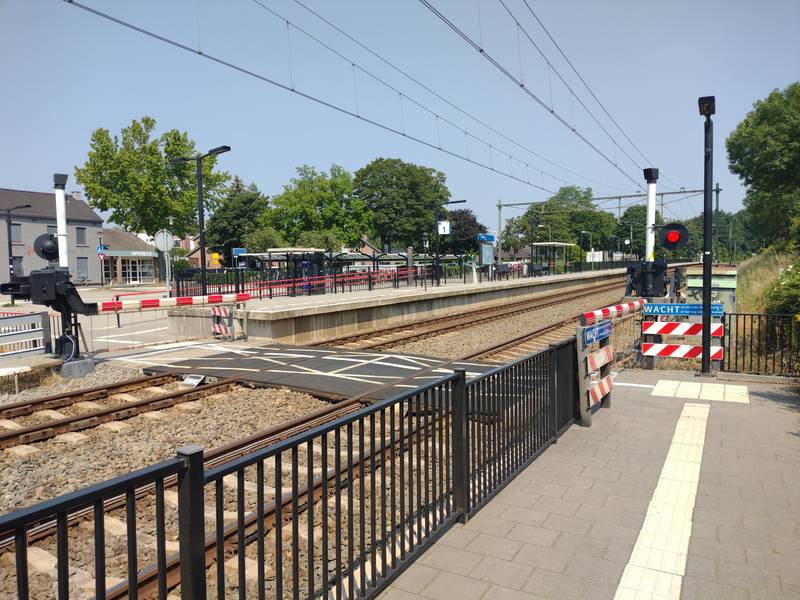 Railroad crossing with closed railway barriers at Bunde train station.