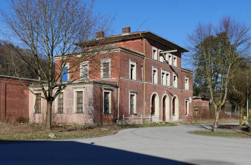 Verfallenes Empfangsgebäude des ehemaligen Bahnhofs Neuötting von der Straßenseite.