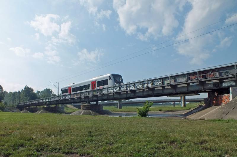 Die Eisenbahnbrücke über das Elsterhochflutbett in Leipzig, dahinter die 2013 erbaute Straßenbrücke