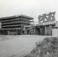 164158, Gezicht op de oostelijk vleugel van het in aanbouw zijnde N.S.-station Rotterdam C.S. te Rotterdam, met rechts de oostelijke portico met de sculptuur naar ontwerp van J. H. Baas (en toegang tot het oude D.P.-station)., Gerdessen, D.C. (Nederlandse Spoorwegen), fotograaf