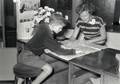 168011, Afbeelding van de 9-jarige Maarten van Traa uit Groningen en een informatrice van de Nederlandse Spoorwegen in het Inlichtingenbureau van de N.S. in het N.S.-station Utrecht C.S. te Utrecht.