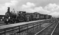 161280, Afbeelding van de stoomlocomotief nr. 1445 (serie 1300/1400) van de N.S. met een trein langs het perron van het N.S.-station Elst te Elst.