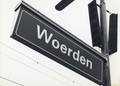 170748, Afbeelding van het stationsnaambord in de nieuwe huisstijl van N.S. op het N.S.-station Woerden te Woerden., Nederlandse Spoorwegen, fotograaf