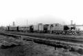 24675, Afbeelding van de stoomlocomotief nr. 64 (serie 61-65) van de N.C.S (later vernummerd tot de serie 5401-5405 van de N.S.). met enkele rijtuigen op het emplacement aan de noordzijde van het Centraal Station te Utrecht. Op de achtergrond enkele huizen aan de Cremerstraat. Links op de achtergrond de romp van molen De Kat aan de Vleutenseweg., Jochmann Disco, fotograaf