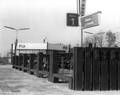 150308, Gezicht op de fietsenstalling (met bielsbouwsels) van het N.S.-station Geleen-Lutterade te Geleen. Op de achtergrond staat het stationsgebouw., Nederlandse Spoorwegen, fotograaf