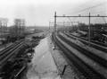 76498, Gezicht op de gereedgekomen verhoogde en geëlectrificeerde spoorbaan aan de zuidzijde van het Centraal Station van de N.S. te Utrecht, ter hoogte van het nieuwe spoorviaduct over de Bleekstraat (midden). Links nog de twee sporen van de hulpspoorbaan en op de achtergrond de restanten van de gesloopte Machinefabriek Drakenburgh (Croeselaan 142)., Nederlandse Spoorwegen, fotograaf