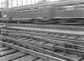 154815, Gezicht op het emplacement aan de westzijde van het N.S.-station Amsterdam C.S. te Amsterdam met een passerende trein., Nederlandse Spoorwegen, fotograaf