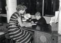 168012, Afbeelding van de 9-jarige Maarten van Traa uit Groningen en een informatrice van de Nederlandse Spoorwegen in het Inlichtingenbureau van de N.S. in het N.S.-station Utrecht C.S. te Utrecht.