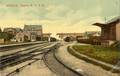 11905, Gezicht op het emplacement van het station van de H.IJ.S.M. (Hollandsche IJzeren Spoorweg-Maatschappij) te Rhenen, met links het stationsgebouw, op de achtergrond het viaduct in de Herenstraat / Grebbeweg en rechts de goederenloods.