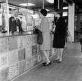 152415, Interieur van het N.S.-station Driebergen-Zeist te Driebergen-Rijsenburg: loketbalie, met enkele dames bij het loket., Nederlandse Spoorwegen, fotograaf