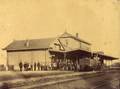 119426, Gezicht op het H.S.M.-station Winterswijk te Winterswijk, met het voltallige stationspersoneel en een stoomlocomotief., Onbekend