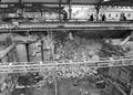 46161, Gezicht op de werkzaamheden ten behoeve van de aanleg van de Noordertunnel onder het Stationsplein te Utrecht, met op de achtergrond de perrons van het Centraal Station. Achter de gestapelde putringen links bevindt zich de bocht van de reeds bestaande perrontunnel., Fotodienst GAU, fotograaf