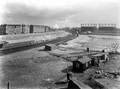164214, Overzicht van de Spoorwegwerken Amsterdam Oost, vanuit het seinhuis Post VI bij het N.S.-station Amsterdam Muiderpoort, uit het noordwesten, met links een gedeelte van het noordelijke perron en het talud van de verhoogde spoorbaan richting Watergraafsmeer. Rechts op de achtergrond de gashouders van de Oostergasfabriek.