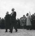 171110, Afbeelding van commissaris van de Koningin in de provincie Noord-Holland dr. M.J. Prinsen en burgemeester J.G.S. Bruinsma van Beverwijk tijdens de opening van het nieuwe N.S.-station Beverwijk, voor het hijsen van de vlaggen op het voorplein., Hessels, L. (Nederlandse Spoorwegen), fotograaf