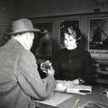 169310, Afbeelding van een informatrice van het inlichtingenbureau in het N.S.-station Den Haag H.S. te Den Haag., Hessels, L. (Nederlandse Spoorwegen), fotograaf