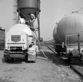 846560, Afbeelding van het overladen van cement van een silowagen van de N.S. naar een vrachtauto van Usilo op de laad- en losplaats van het N.S.-station Bilthoven te De Bilt., Hessels, L. (Nederlandse Spoorwegen), fotograaf