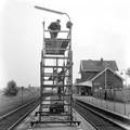 824986, Afbeelding van werkzaamheden aan de lantaarns op het perron van het N.S.-station Beesd met behulp van een rolsteiger, met op de achtergrond het stationsgebouw., Nederlandse Spoorwegen, fotograaf