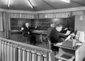 159667, Interieur van het seinhuis bij het N.S.-station Arnhem te Arnhem met de treindienstleiders bij het NX-bedieningstableau., Schaik, W.P.F.M. van (Nederlandse Spoorwegen), fotograaf