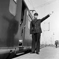 841576, Afbeelding van een conducteur op een perron van het N.S.-station Utrecht C.S. te Utrecht, tijdens het geven van het vertreksein., Hessels, L. (Nederlandse Spoorwegen), fotograaf