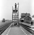 824982, Afbeelding van werkzaamheden aan de lantaarns op het perron van het N.S.-station Beesd met behulp van een rolsteiger, met op de achtergrond het stationsgebouw., Nederlandse Spoorwegen, fotograaf