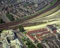 50663, Luchtfoto van het emplacement aan de noordzijde van het Centraal Station te Utrecht, tijdens de bouw van een ongelijkvloerse kruising en de uitbreiding van het emplacement. Links de Daalsetunnel, op de voorgrond de Wolfstraat en omgeving met rechts de voormalige Openbare Lagere School Vlijtstraat 13 en op de achtergrond het Verdomhoekje en de Cremerstraat., Delta-Phot Luchtfotografie, fotograaf