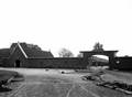 163815, Gezicht op de in aanbouw zijnde nieuwe vleugel van het N.S.-station Roosendaal te Roosendaal, met links de rijwielstalling en rechts de poort naar het terrein van Van Gend & Loos.., Gerdessen, D.C. (Nederlandse Spoorwegen), fotograaf