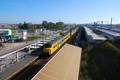 117801, Afbeelding van een trein bestaande uit twee gekoppelde electrische treinstellen Plan V (mat. 1964) van de N.S. bij aankomst op het tijdelijke N.S.-station Utrecht Terwijde te Utrecht, met rechts op de achtergrond het in aanbouw zijnde definitieve station Terwijde aan de verhoogde spoorbaan.
