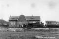 172082, Afbeelding van de stoomlocomotief nr. 1059 (serie 1050-1060) van de H.S.M. (later serie 7100 van de N.S.) met een trein langs het perron van het station Anjum van de N.F.L.S., Onbekend