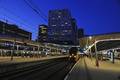 903014, Gezicht op het 7e (rechts) en 8e perron van het Centraal Station (Utrecht Centraal) te Utrecht, tijdens de schemering. Op de achtergrond het Stadskantoor., Het Utrechts Archief, fotograaf