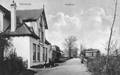 161545, Gezicht op de Heerenweg te Warmond, met op de achtergrond de spoorwegovergang en overwegpost bij het station Warmond van de H.S.M.