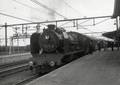 155450, Afbeelding van de stoomlocomotief nr. 7.054 van de N.M.B.S. met een reizigerstrein langs het perron van het N.S.-station Roosendaal te Roosendaal., Gerdessen, D.C. (Nederlandse Spoorwegen), fotograaf