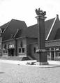 150602, Gezicht op een gedeelte van de voorgevel van het N.S.-station Roosendaal te Roosendaal, met rechts op de voorgrond het monument voor tijdens de Tweede Wereldoorlog gevallen personeelsleden van het station., Nederlandse Spoorwegen, fotograaf