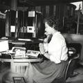 169335, Afbeelding van een informatrice in het inlichtingenbureau van het N.S.-station Utrecht C.S. te Utrecht., Hessels, L. (Nederlandse Spoorwegen), fotograaf